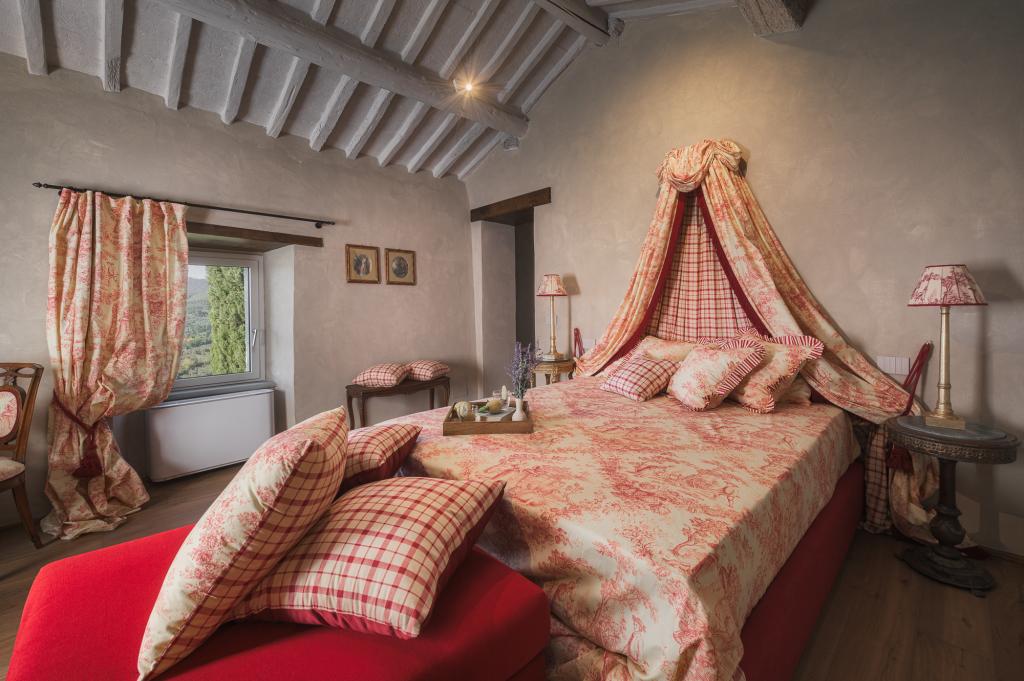 Bedroom at Cortona Escape featuring a large, vaulted ceiling, European king bed, and red and white linens