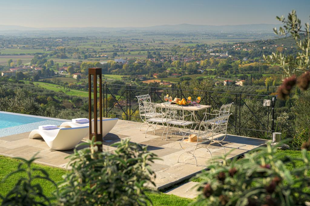 View from Cortona Escape over the tiered gardens and pool area, showing the gently rolling hills beyond