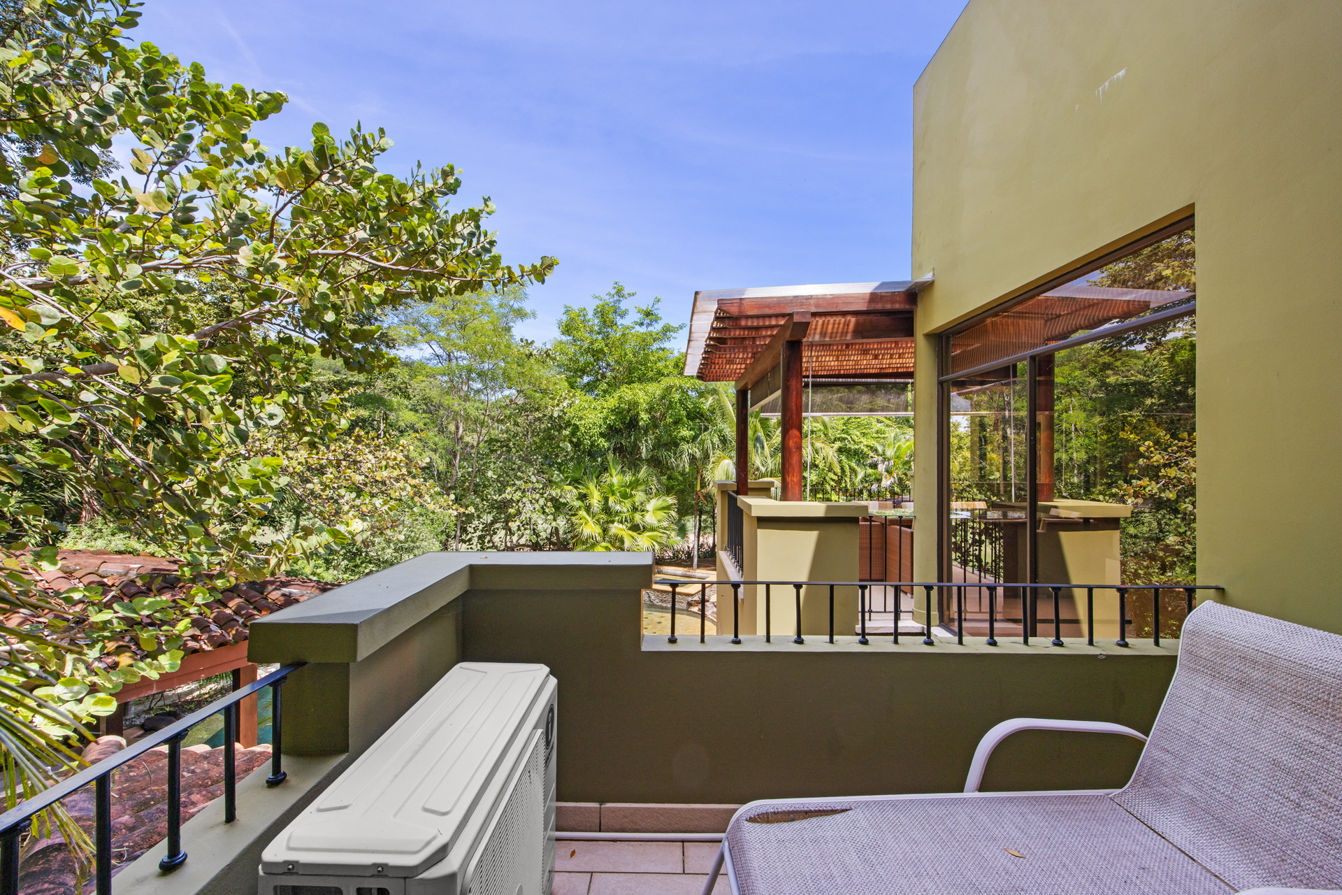 A walk-out balcony patio area at Villa Conchal with a beautiful view of the low treetops