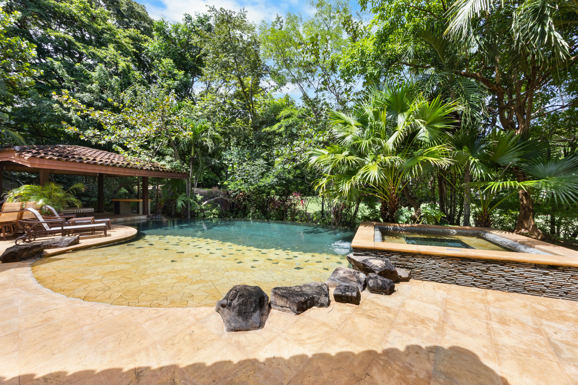 Another view of the pool which shows the beach-style entrance and the relaxing Jacuzzi