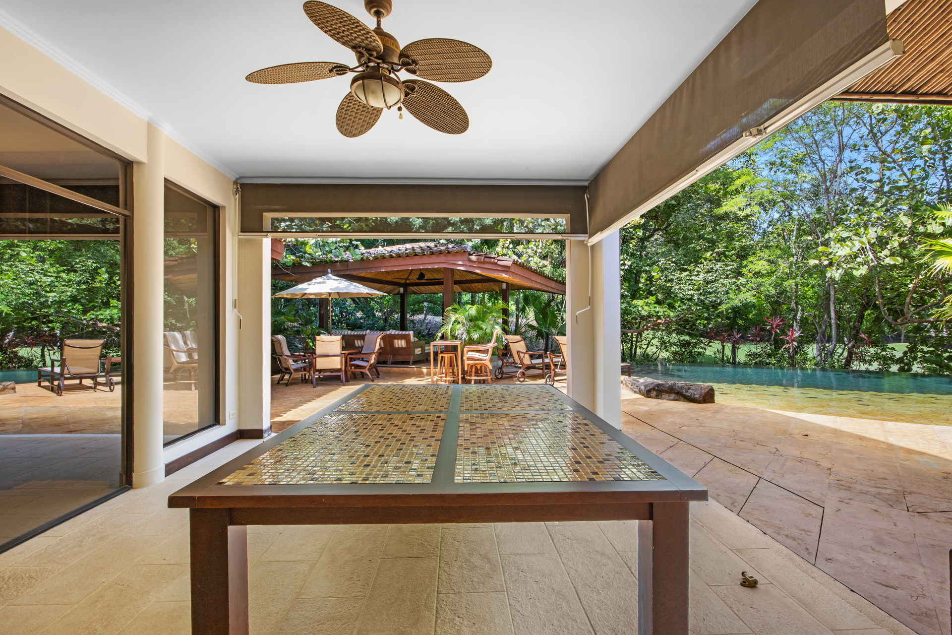 View from the covered patio at Villa Conchal, with its large table, ceiling fans and retractable screens