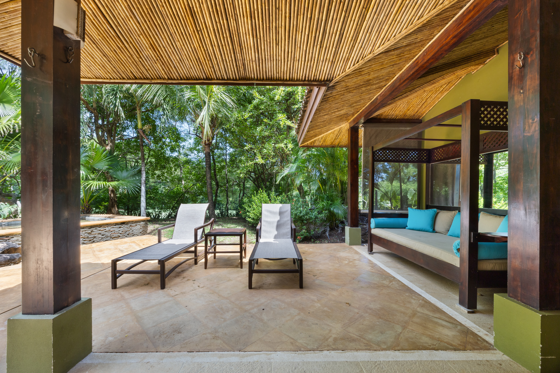 One of the outdoor lounging spaces at Villa Conchal, with a mix of open sun and covered shade