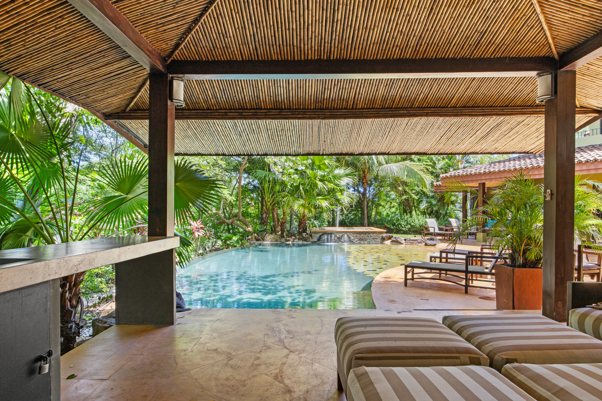 View from the covered outdoor entertaining area at Villa Conchal, showing the covered outdoor dining area and pool.