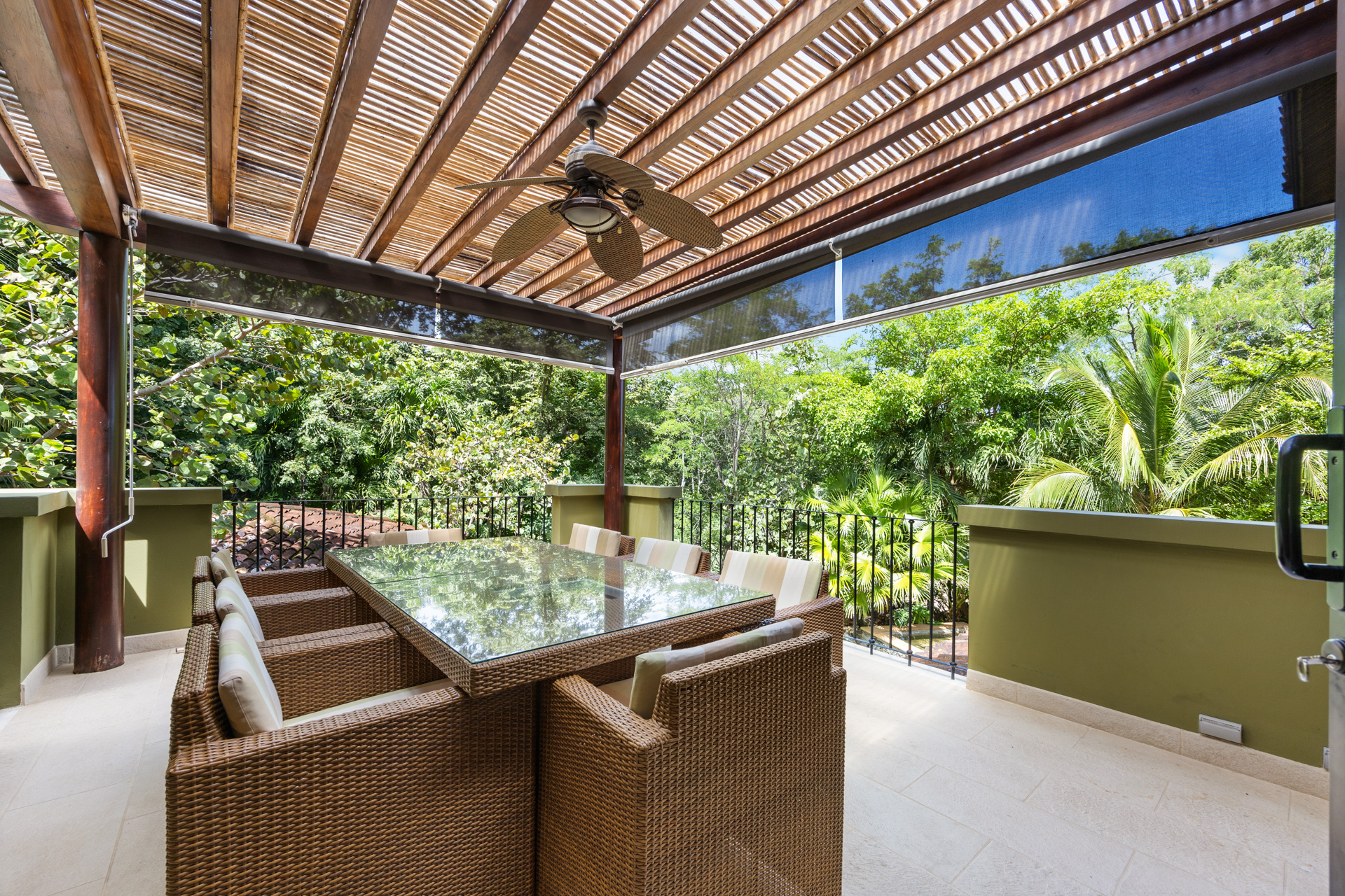 A beautiful, large outdoor patio at Villa Conchal with a glass-topped dining table that seats 8